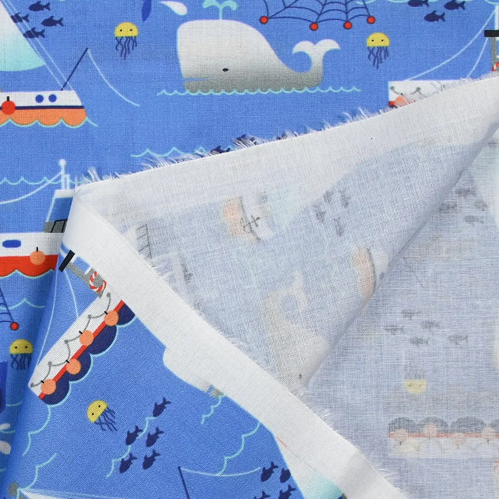 Coton imprimé l'océan et ses bateaux fond bleu